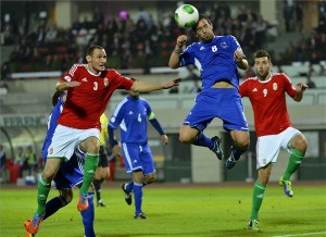 Vanczák Vilmos és Szalai Ádám (piros mezben) között az andorrai Marcio Vieira fejel. Fotó: MTI